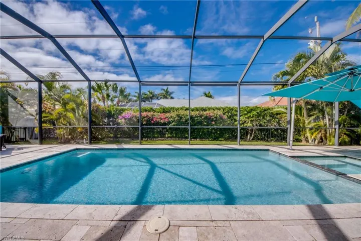 View of swimming pool featuring a lanai, a sunroom, and a pool with connected hot tub