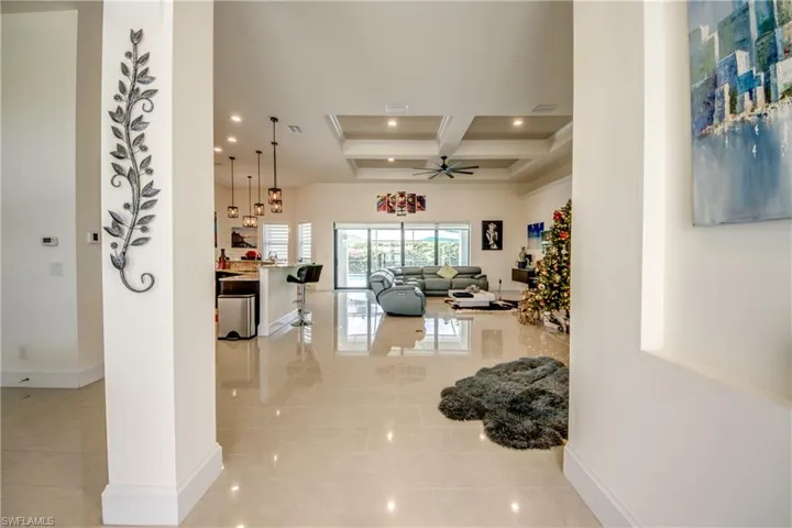 Hallway with coffered ceiling, beamed ceiling, recessed lighting, and light tile patterned flooring