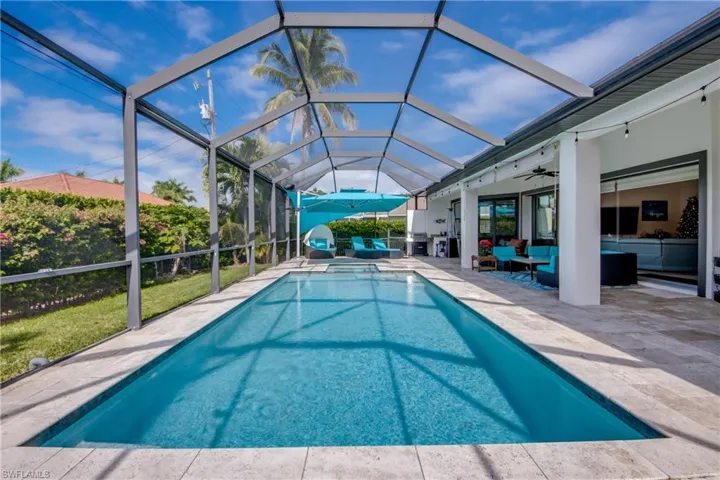 View of swimming pool featuring a sunroom, a patio area, glass enclosure, an outdoor living space, and a pool with connected hot tub