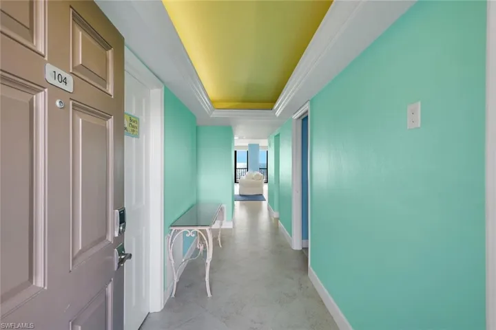 Corridor with a raised ceiling and crown molding