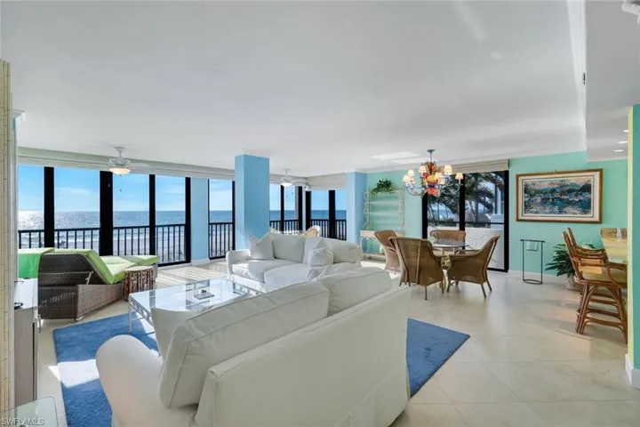 Living area featuring a water view, expansive windows, ceiling fan, and a chandelier