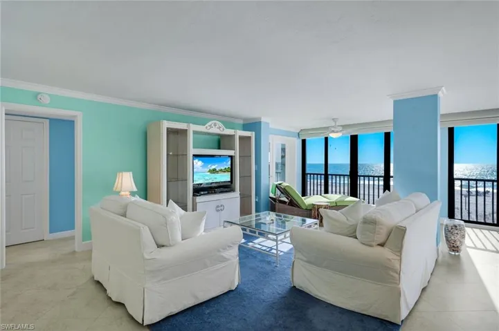 Living room featuring ceiling fan and ornamental molding
