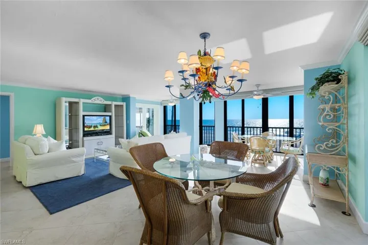 Dining space featuring ornamental molding, suspended lighting, plenty of natural light, expansive windows, and a ceiling fan