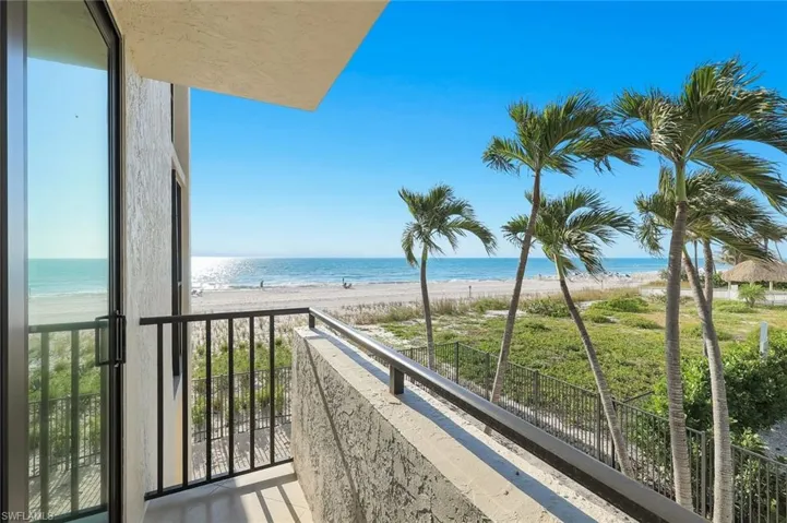 Balcony featuring view of water and beach