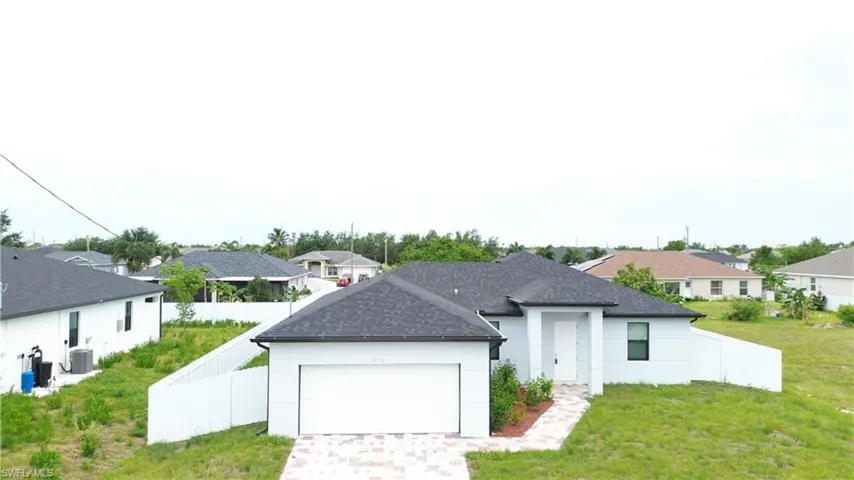 Light blue exterior with white trim, a dark shingle roof, and an attached two-car garage
