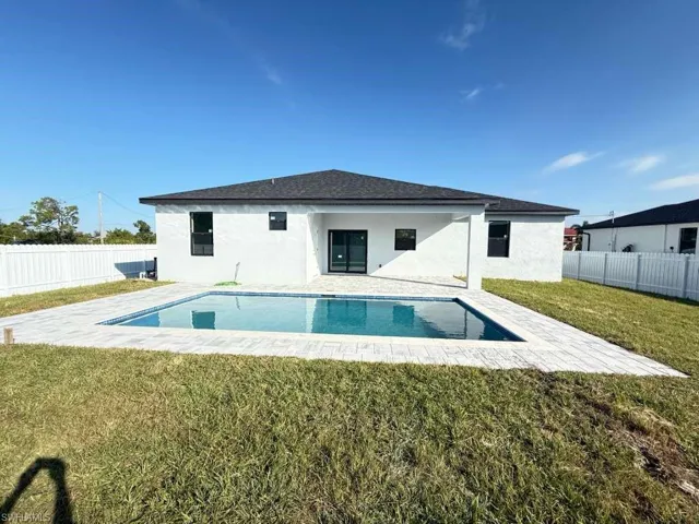 Rear view of house with a patio area, stucco siding, and a fenced backyard