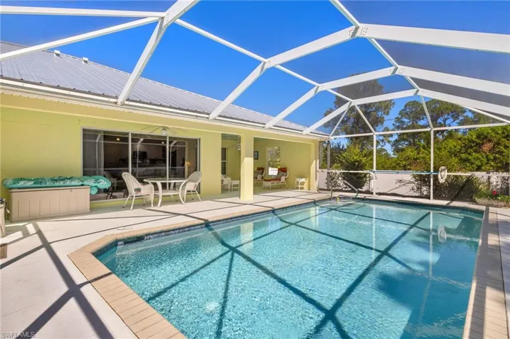 Pool with a patio area and glass enclosure