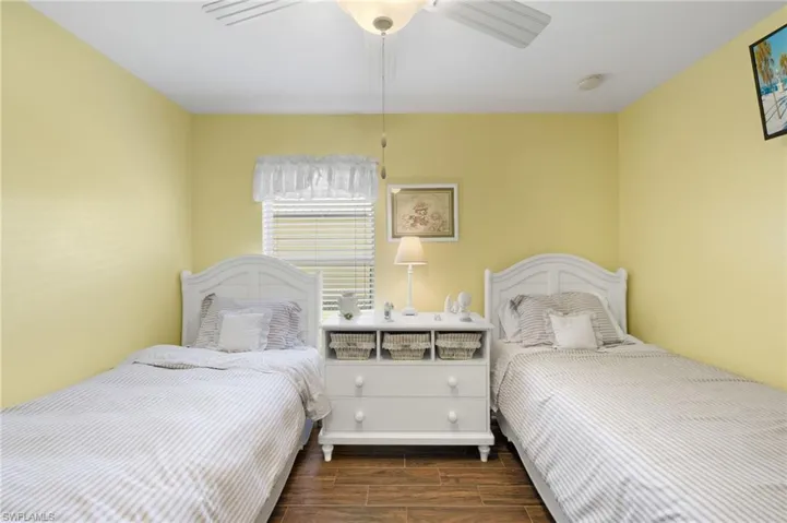 Bedroom with a ceiling fan and wood tiled floor