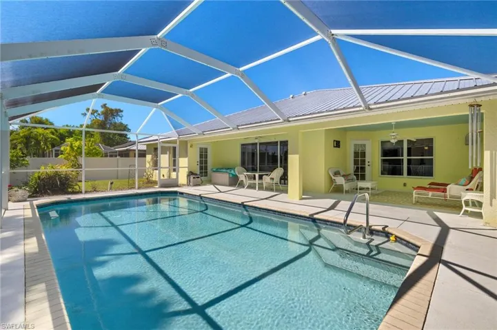 View of pool featuring glass enclosure, a patio, a ceiling fan, a fenced in pool, and fence