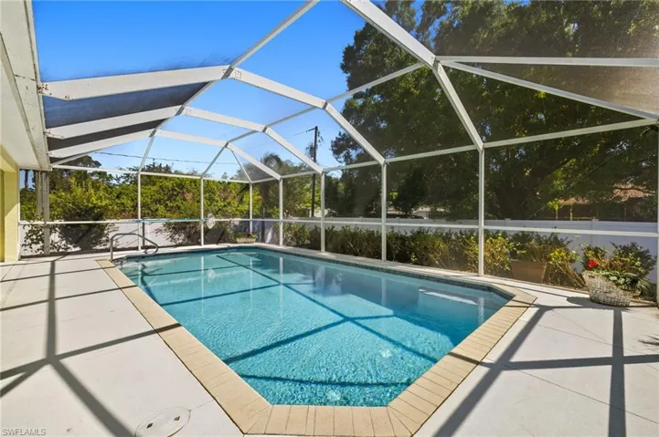 Pool featuring glass enclosure and a patio