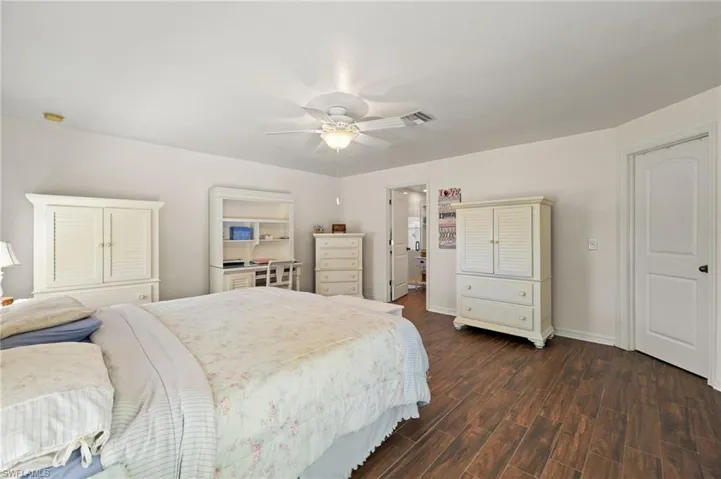 Bedroom featuring visible vents, baseboards, dark wood-type flooring, and ceiling fan