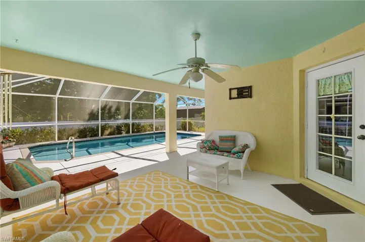 Pool with glass enclosure, a patio, and ceiling fan