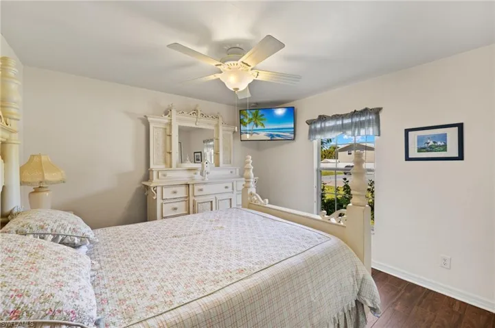 Bedroom featuring a ceiling fan, baseboards, and dark wood-style flooring