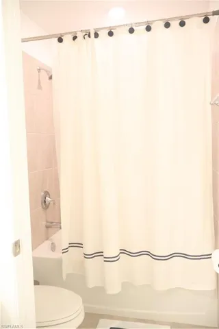 Bathroom featuring shower / tub combo and tile patterned floors