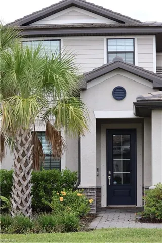 Entrance to property featuring stone siding and stucco siding