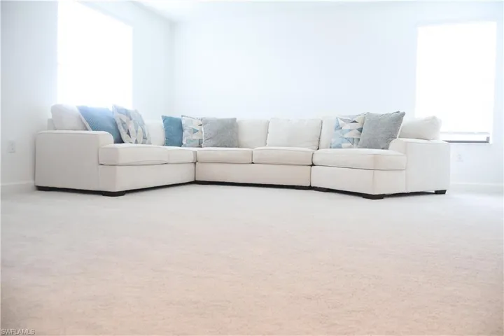 Carpeted living area featuring baseboards