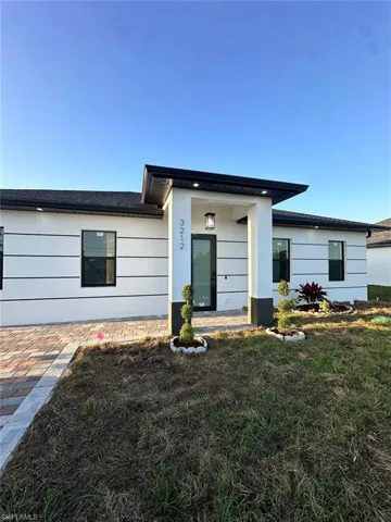 Back of property with a lawn