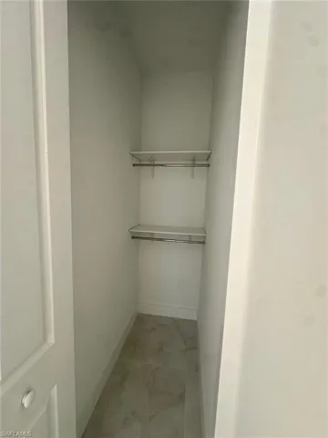 Spacious closet featuring marble finish floor