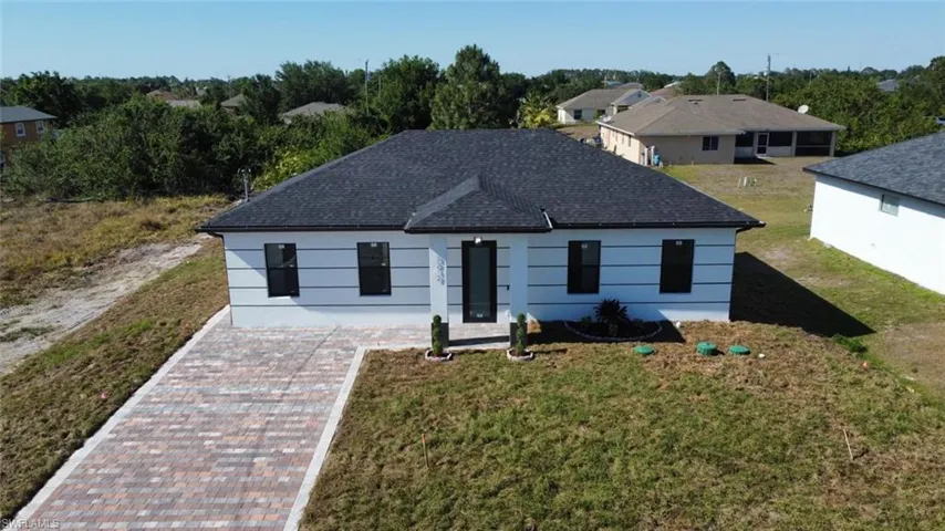 View of front of property with roof with shingles and a front yard