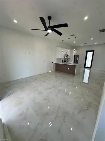 Unfurnished living room featuring visible vents, recessed lighting, and marble finish floor