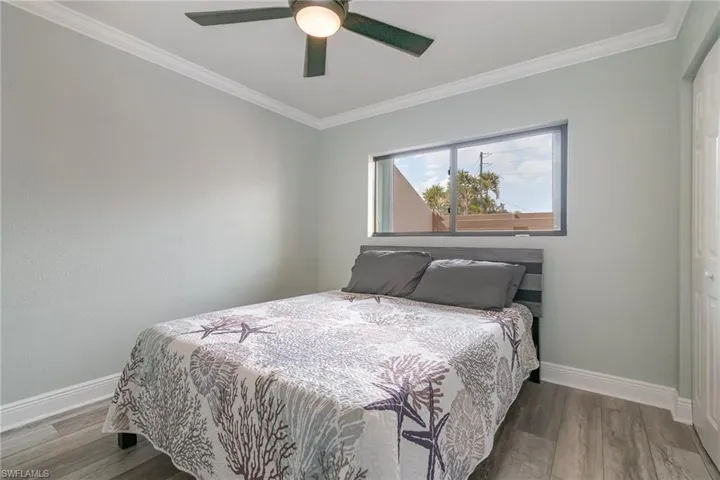Bedroom with baseboards, wood finished floors, and crown molding