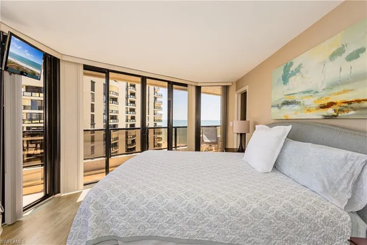 Bedroom featuring access to exterior, floor to ceiling windows, and wood finished floors