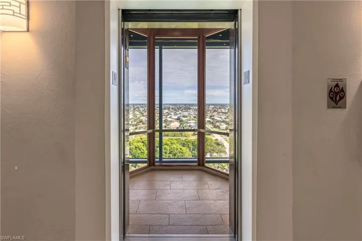Doorway to outside with stone tile flooring and a textured wall