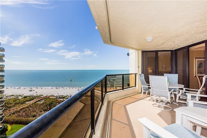 Balcony featuring a water view and a beach view