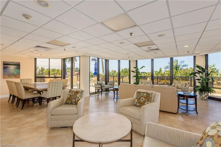Living area featuring light tile patterned floors, a drop ceiling, and floor to ceiling windows