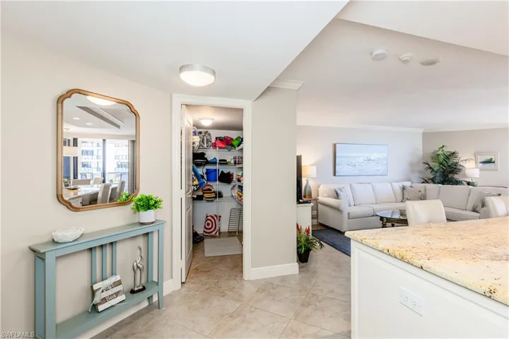 Corridor featuring light tile patterned floors, ornamental molding, and baseboards