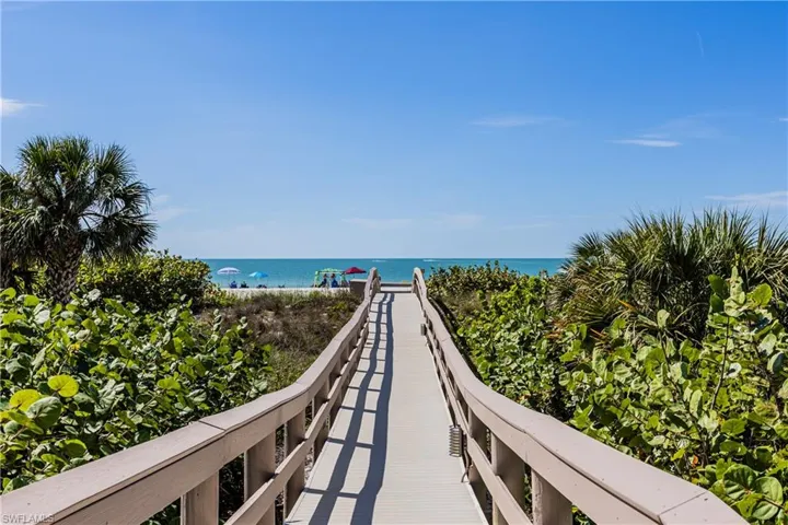 View of home's community featuring a water view and a beach view