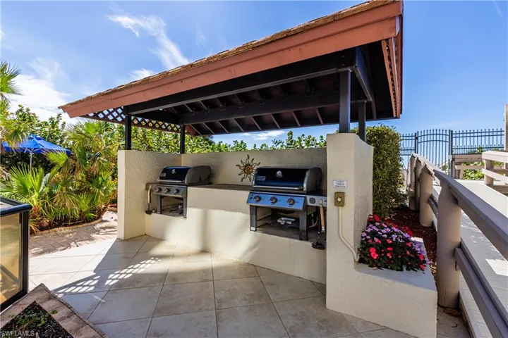 View of patio with a grill, fence, and an outdoor kitchen