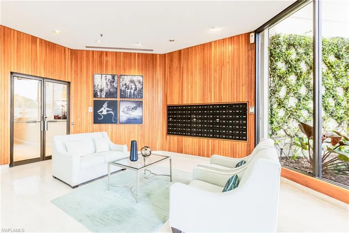 Living area with expansive windows, wood walls, and recessed lighting