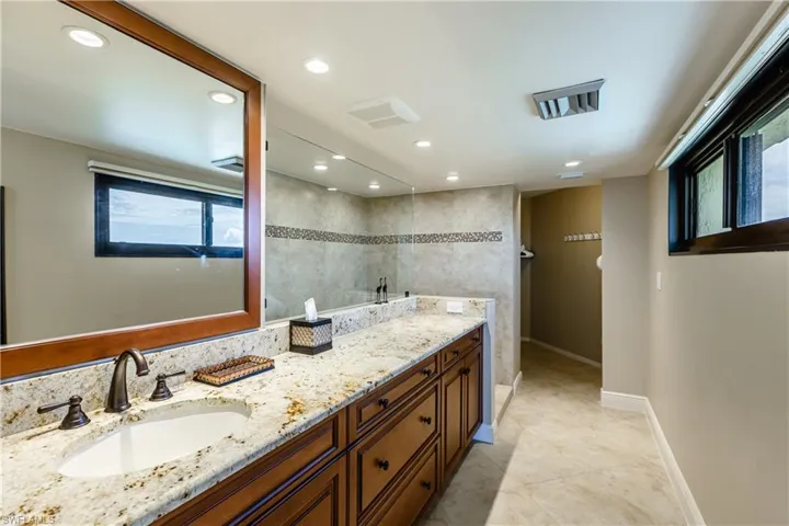 Bathroom with recessed lighting, vanity, baseboards, and tile patterned floors