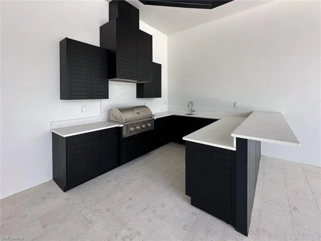 Kitchen with a kitchen bar, kitchen peninsula, & sink