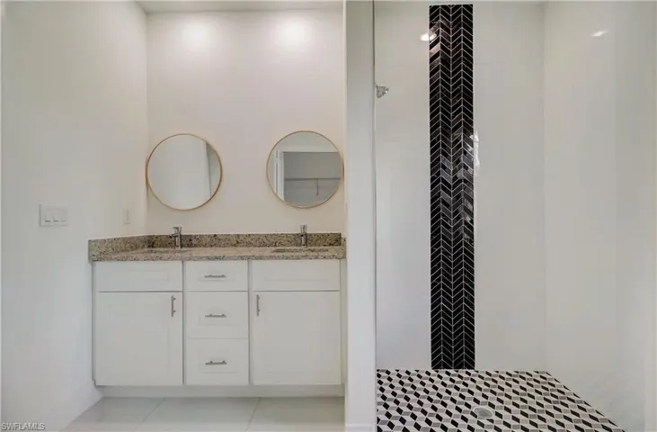 Bathroom featuring double vanity and tile patterned flooring