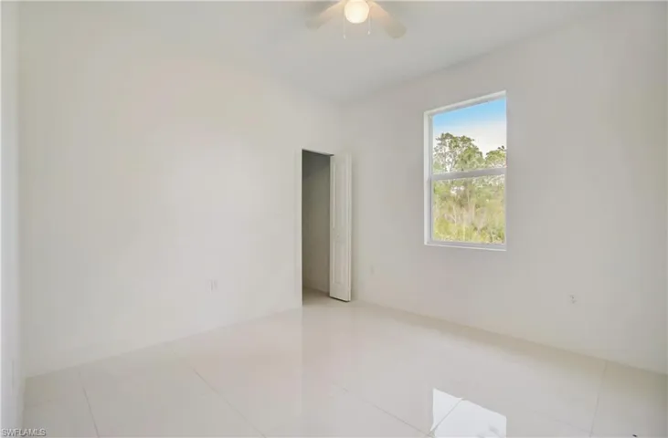 Tiled spare room with ceiling fan