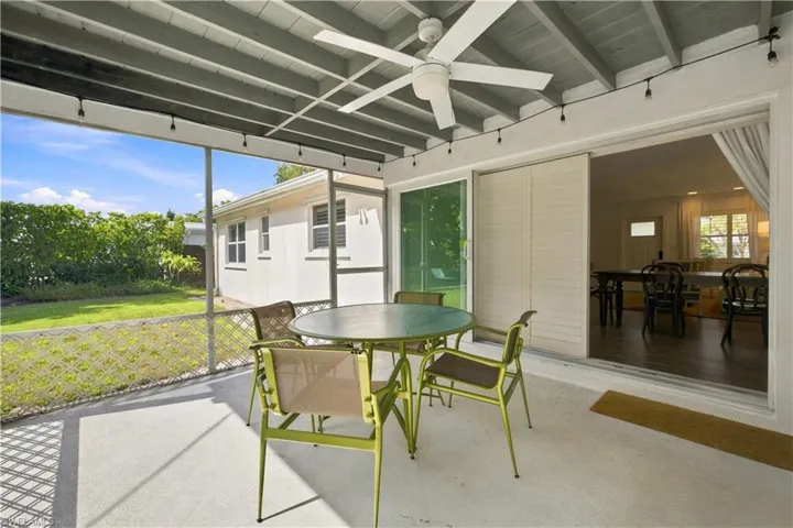 Screened patio with a ceiling fan, concrete flooring, and sliding glass doors