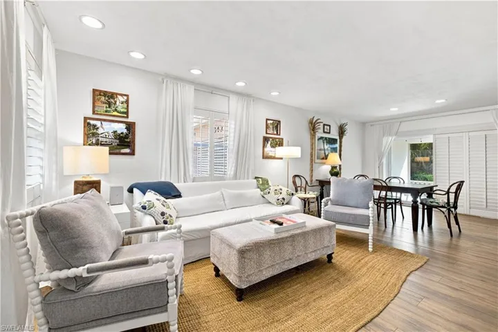 Recessed ceiling lighting, wood-finish flooring, and white plantation shutters