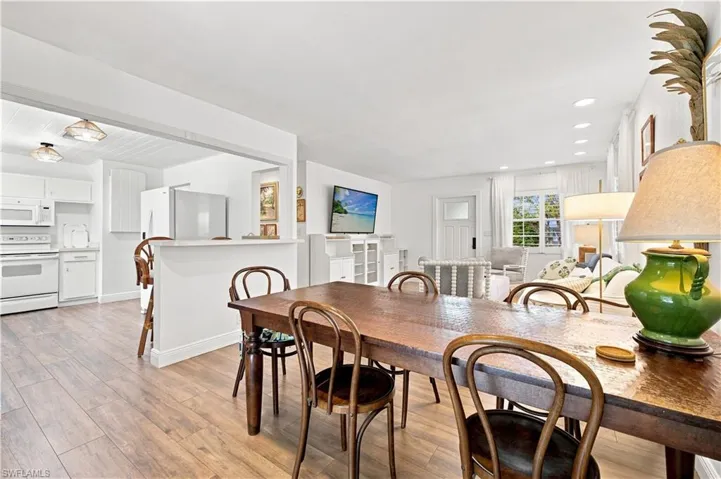 Open-concept living area with wood-finish flooring, recessed lighting, and white trim throughout