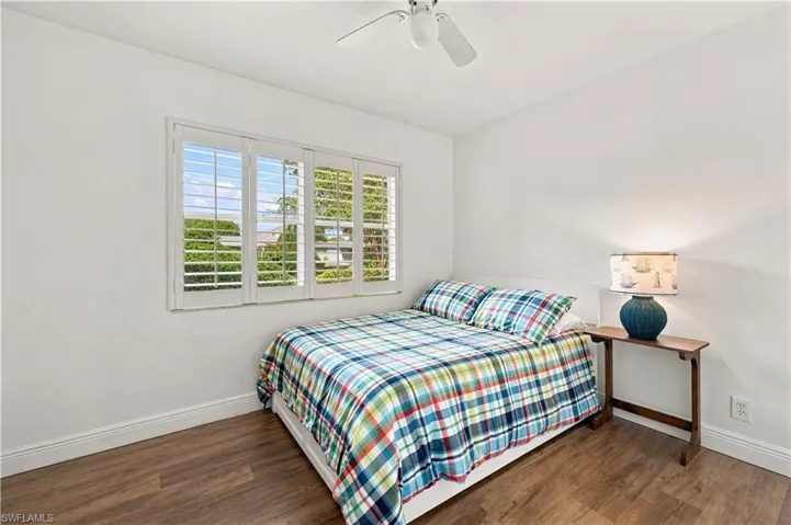 White walls, wood-finish flooring, and a ceiling fan