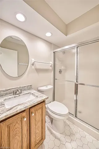 Full bathroom with vanity, a shower stall, light tile patterned floors, and recessed lighting