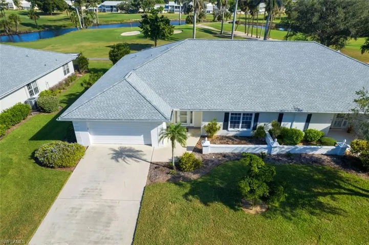 View of front facade with a front lawn, stucco siding, concrete driveway, and an attached garage
