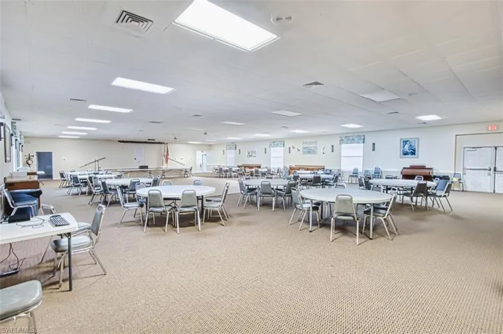 Dining space featuring light colored carpet and a drop ceiling