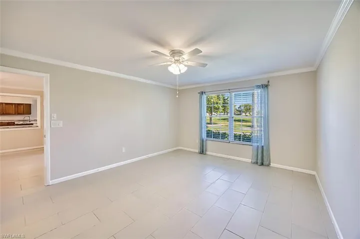 Unfurnished room featuring ornamental molding, light tile patterned floors, and ceiling fan