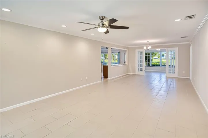 Unfurnished room featuring ornamental molding, recessed lighting, a ceiling fan, and a chandelier