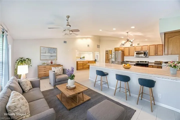 *VIRTUALLY STAGED*Living area with light tile patterned flooring, lofted ceiling, recessed lighting, and ceiling fan