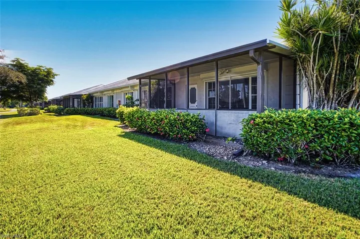 Back of house featuring a sunroom and a yard