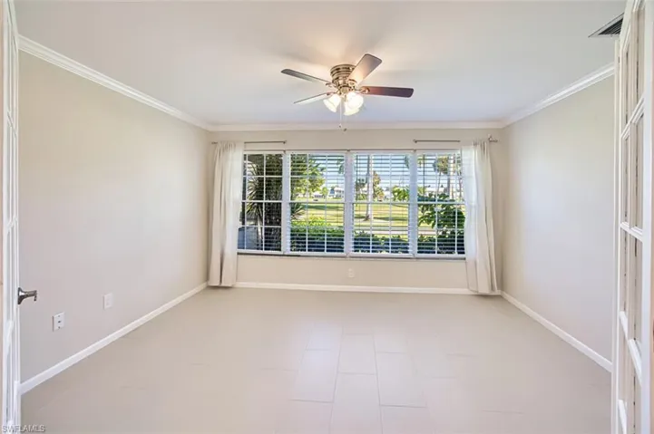 Spare room featuring crown molding, healthy amount of natural light, and a ceiling fan