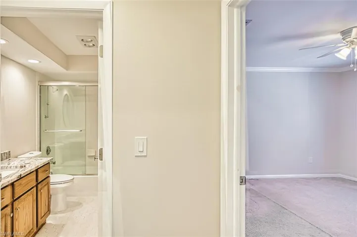 Full bath featuring vanity, bath / shower combo with glass door, ornamental molding, ceiling fan, and recessed lighting